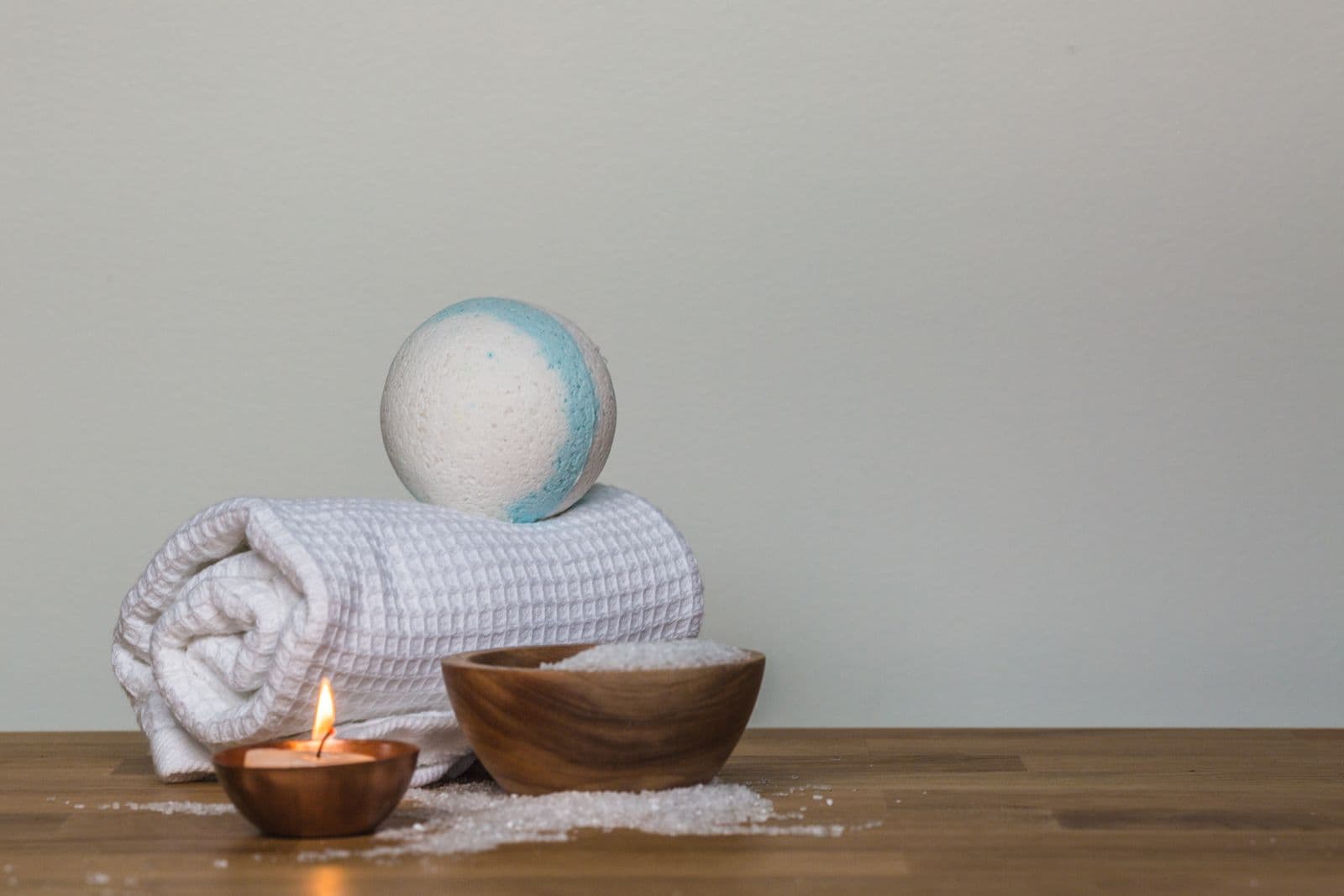 Không gian spa thư giãn với khăn cuộn, nến và vật dụng chăm sóc cơ thể